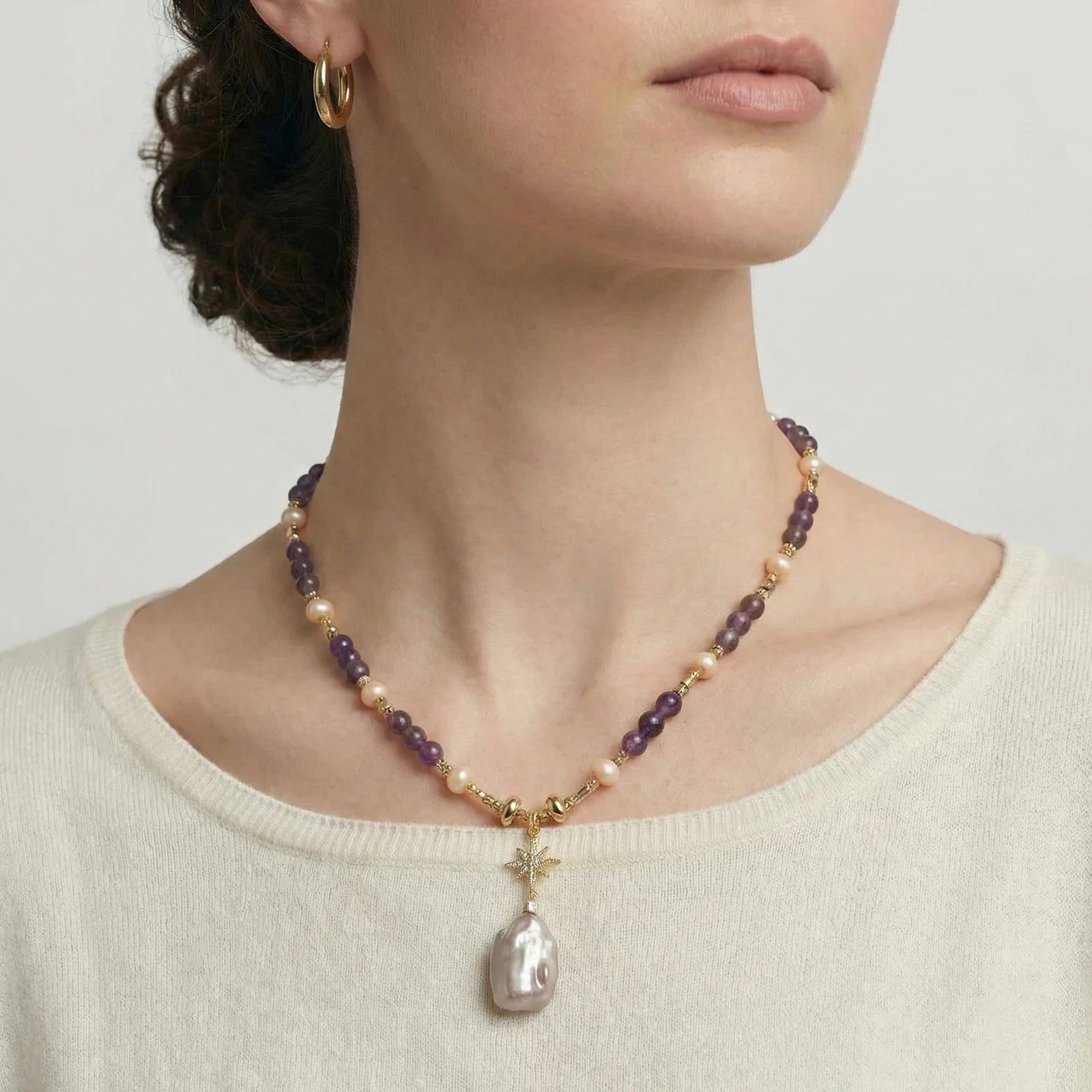 Necklace with a pendant worn by a person on a neutral background