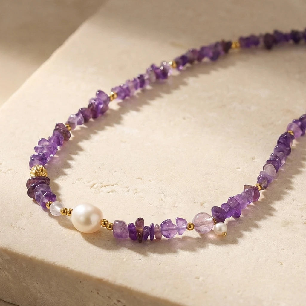 purple amethyst beads and a pearl on stone slab
