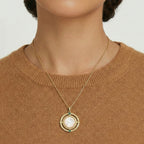 Necklace with a pendant worn by a person against a neutral background