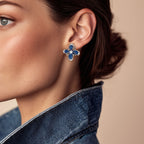 Close-up of a woman wearing a blue floral earring with a beige background