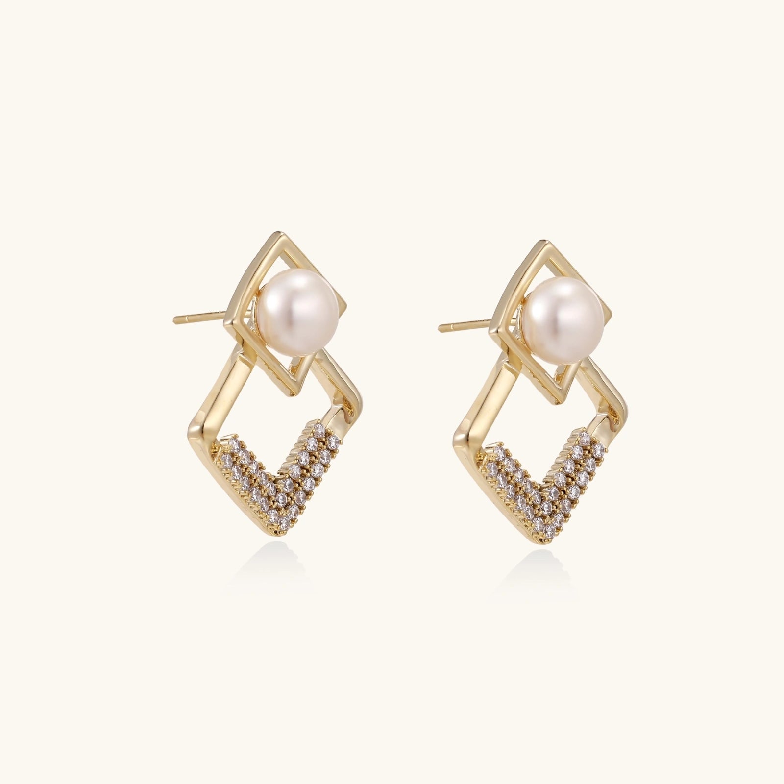 geometric Gold earrings with pearl centers on a white background