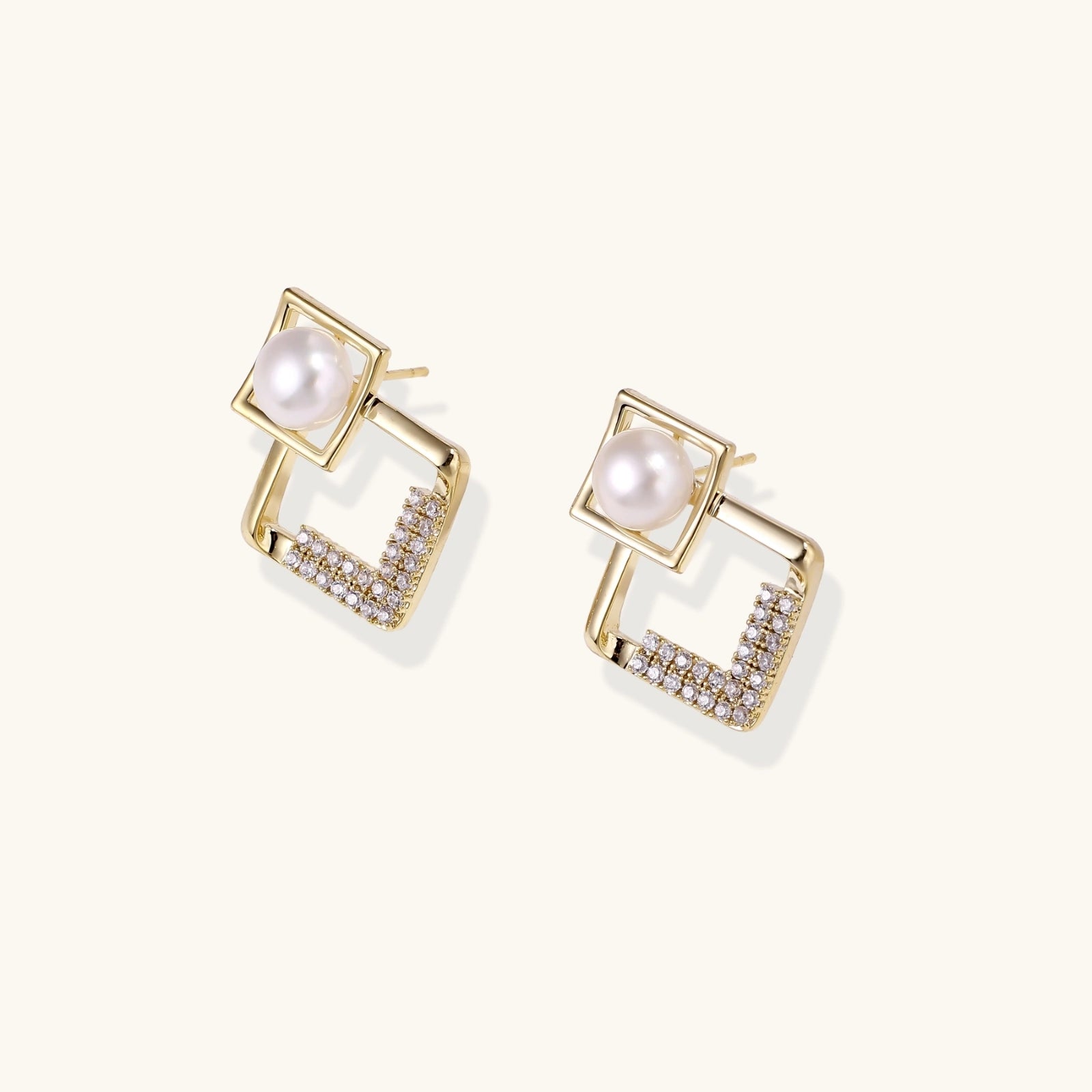 Gold earrings with pearl and zirconia accents on a white background