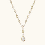 Gold and pearl necklace on a light beige background