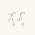 Pair of silver earrings with pink pearls on a white background