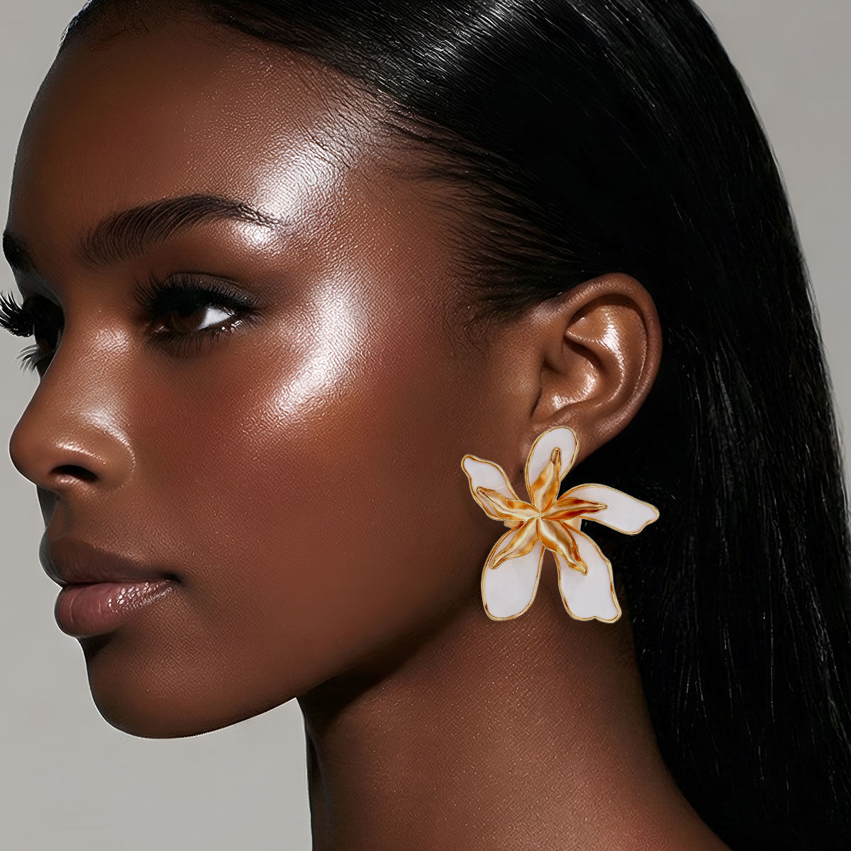 Close-up of a woman wearing a floral earring with a neutral background