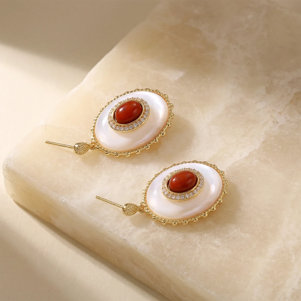 Golden Hour Mother of Pearl Drop Earrings on a stone
