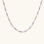 Delicate 18K gold vermeil necklace with alternating lavender zirconia beads and white freshwater pearls on cream background