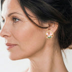 Close-up of a woman wearing floral earrings with a blurred background