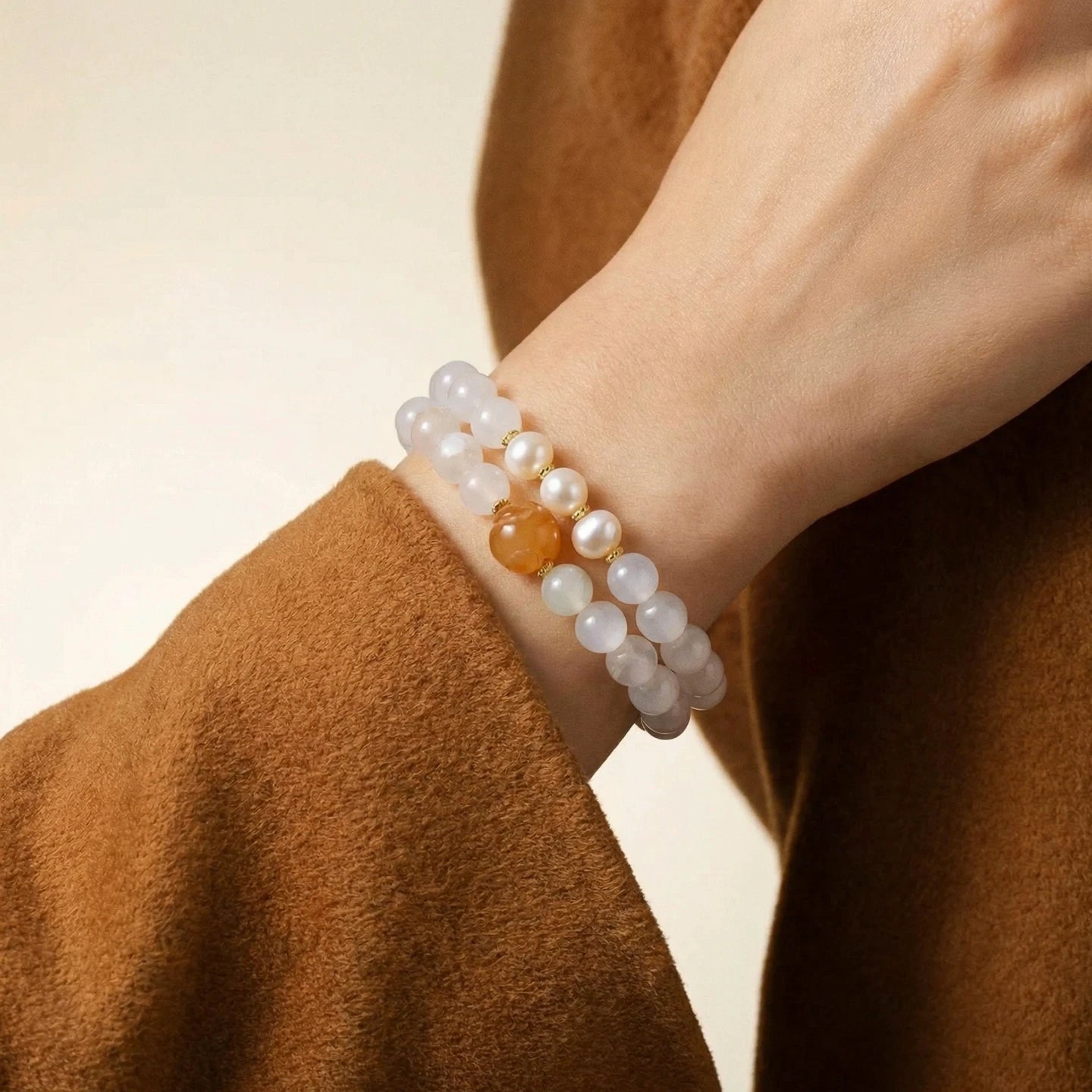 Jade Pearl bracelet with a central amber bead on a wrist against a neutral background