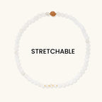 White beaded stretchable bracelet with a brown bead on a white background