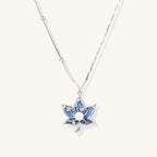 Gold-plated lotus pendant necklace with blue zirconia stones and white beads on adjustable layered chains