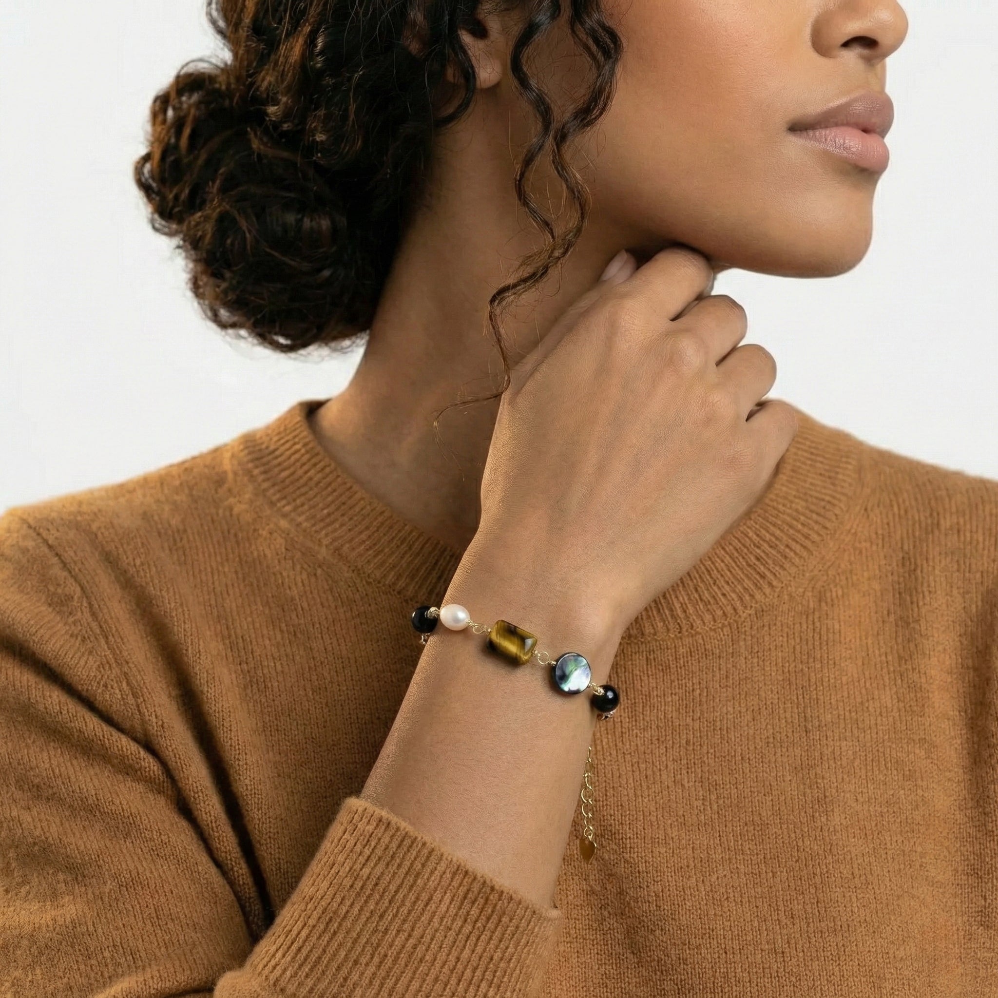 Woman wearing a bracelet with colorful beads on a plain background