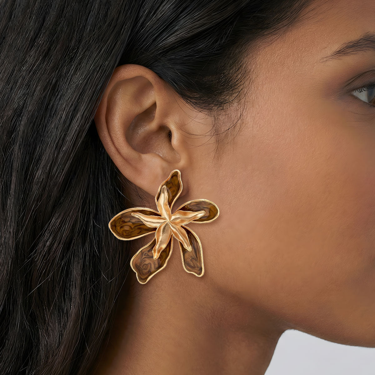 Close-up of a person wearing a gold butterfly earring.