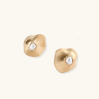 Gold earrings with a central pearl on a white background