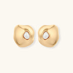 Gold earrings with pearl centers on a white background