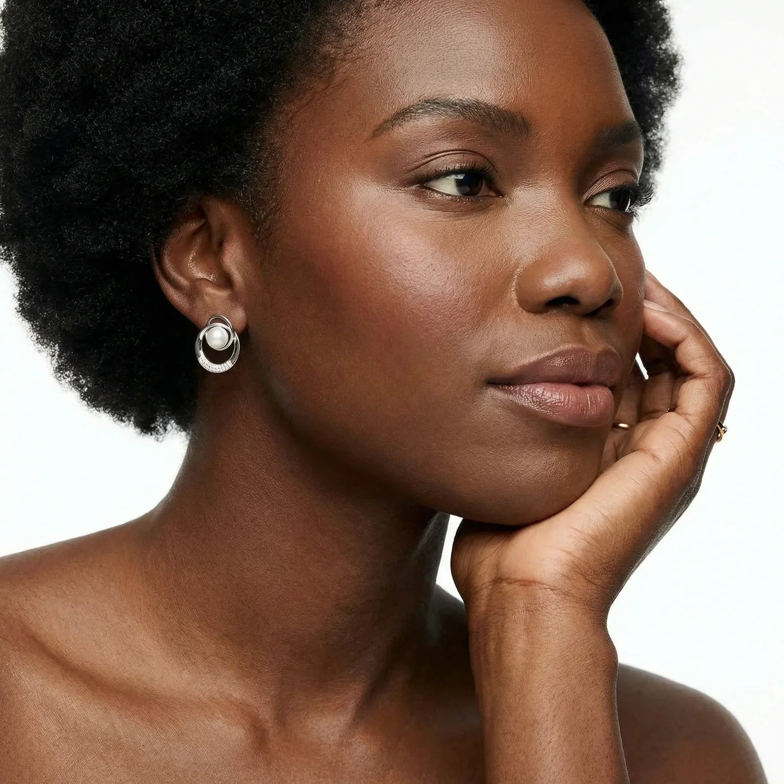 Woman with a thoughtful expression, wearing earrings, on a white background