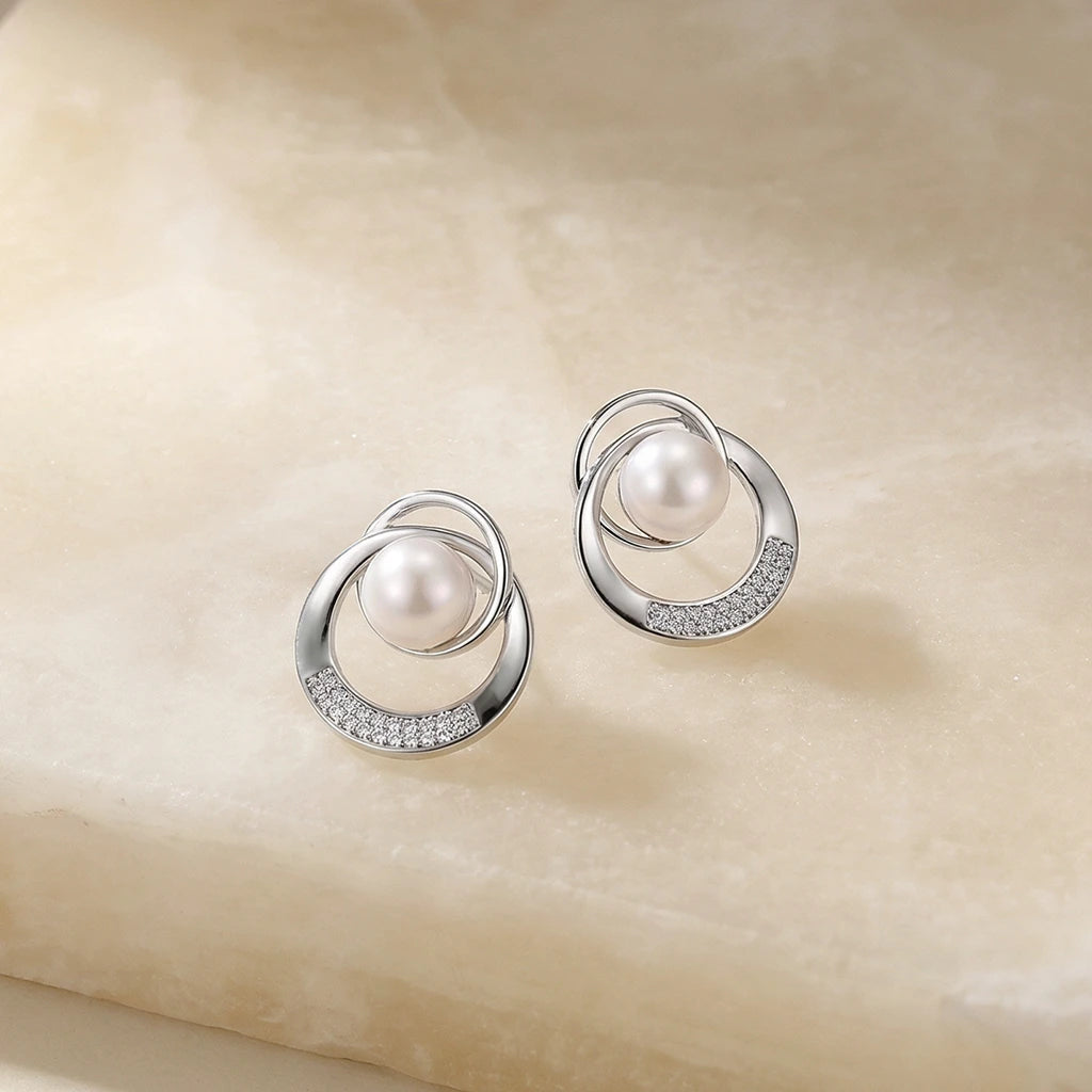 Orbit pearl earrings on fabric