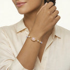 Woman wearing a pastel rose quartz bracelet with a white background