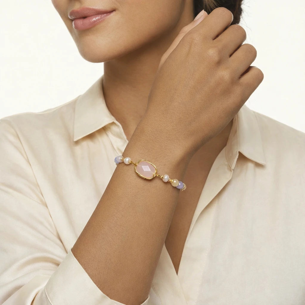 Woman wearing a pastel rose quartz bracelet with a white background
