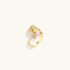 Gold-plated sculptural ring featuring a baroque pearl wrapped in a delicate rose and vine cage design