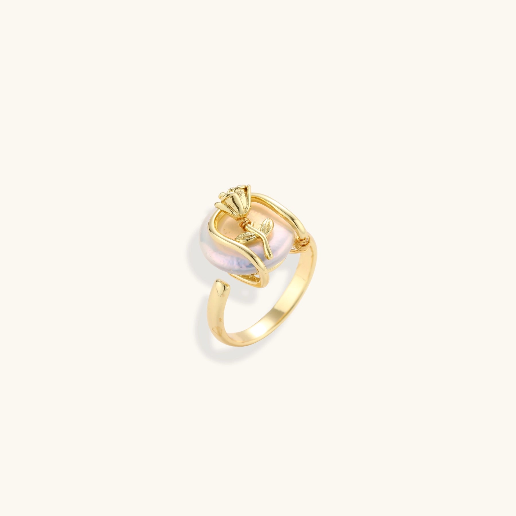 Gold-plated sculptural ring featuring a baroque pearl wrapped in a delicate rose and vine cage design