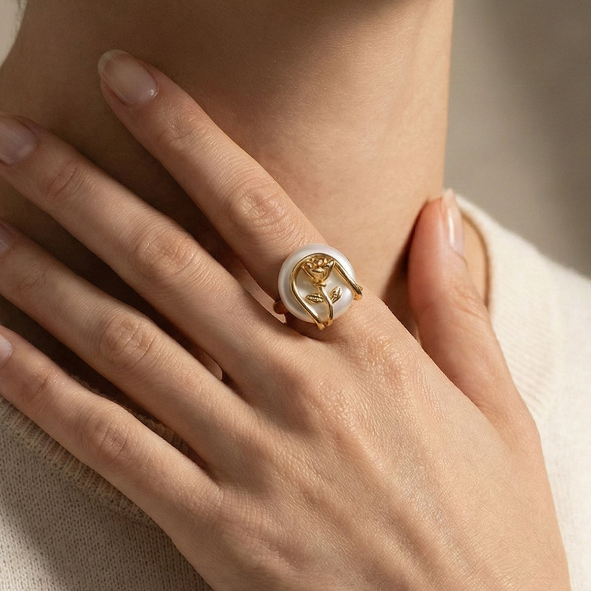 Close-up of a hand wearing a gold ring with a circular design.