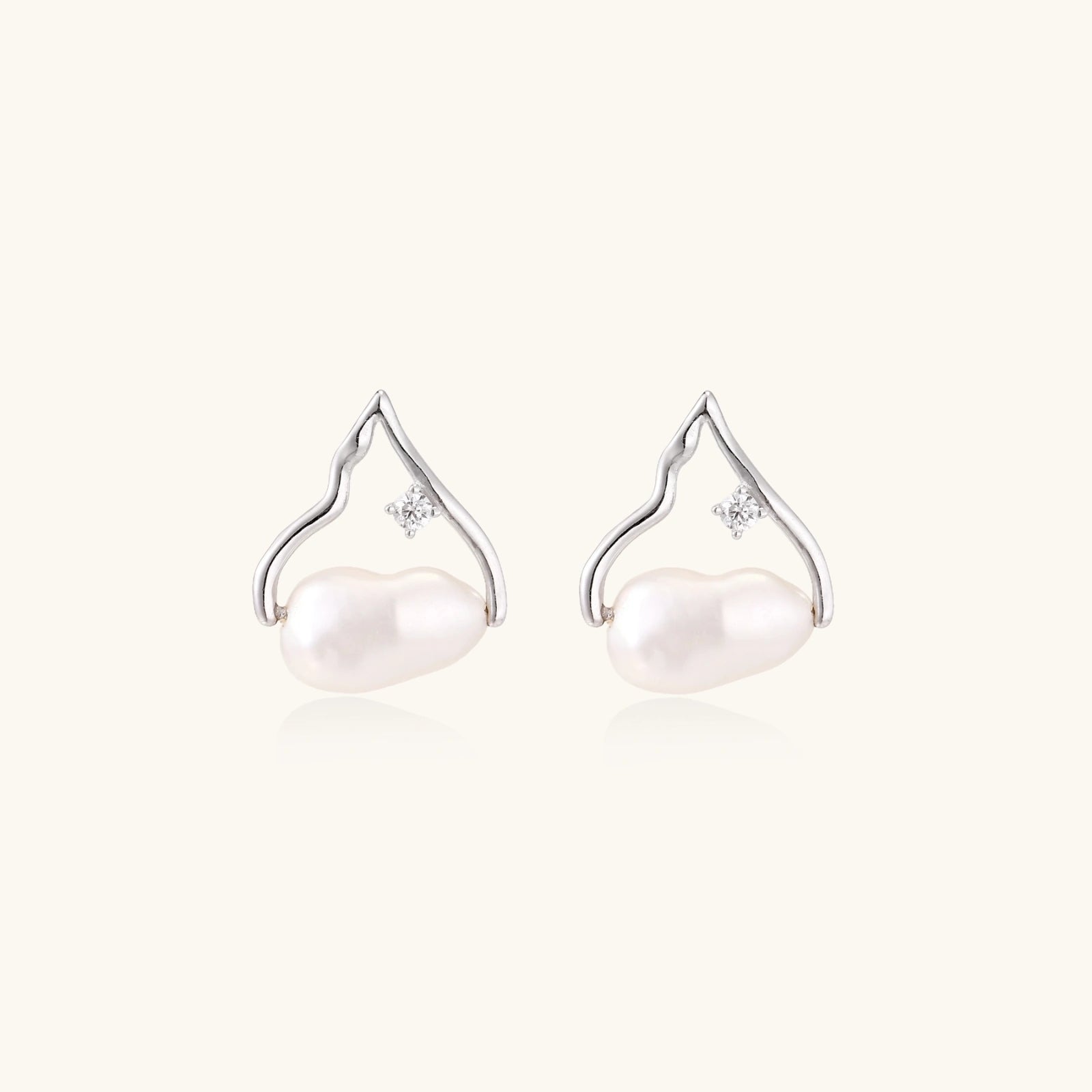 Pair of pearl earrings with silver hooks on a white background