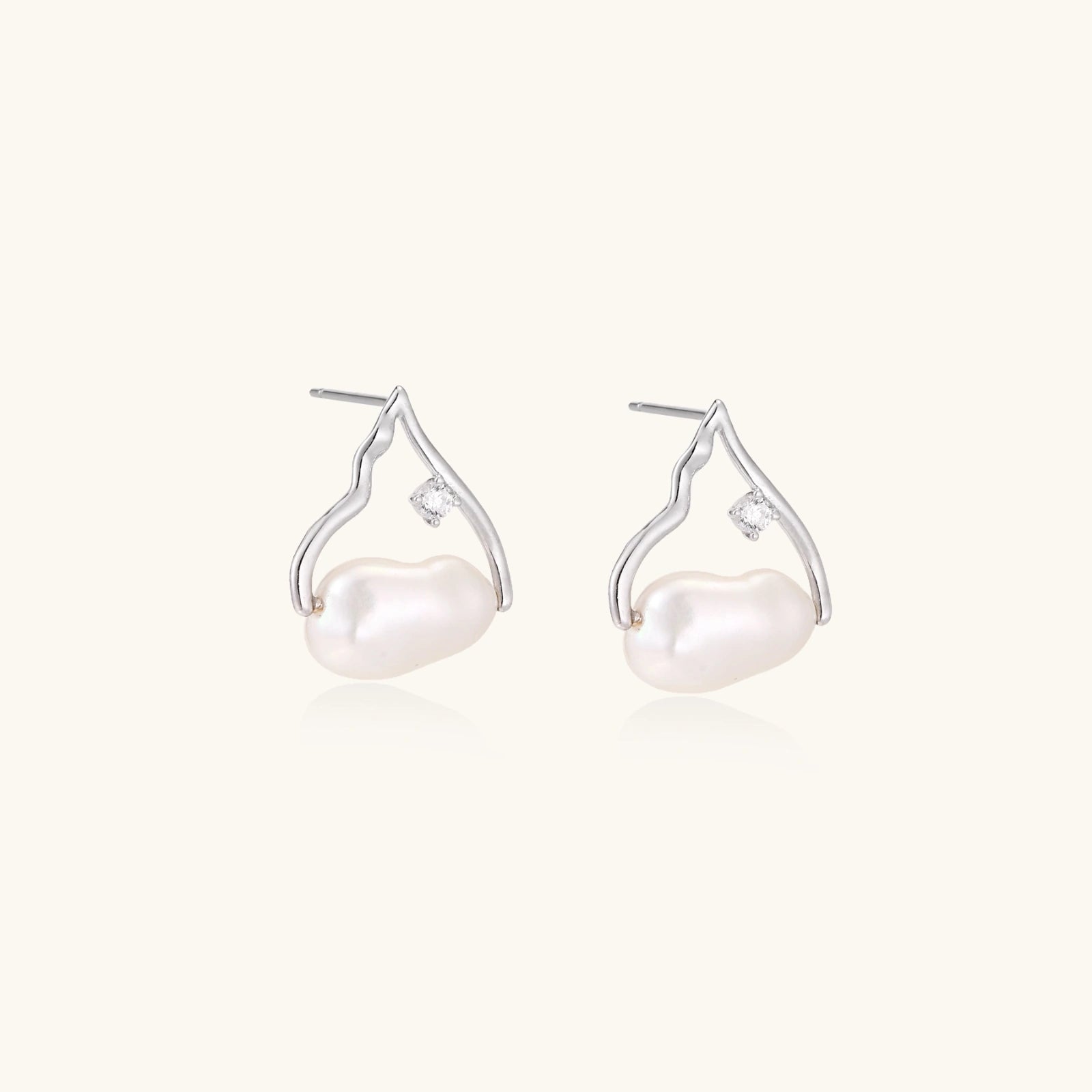 Pair of pearl earrings with silver hooks on a white background