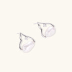 Pair of silver earrings with clear gemstones on a white background