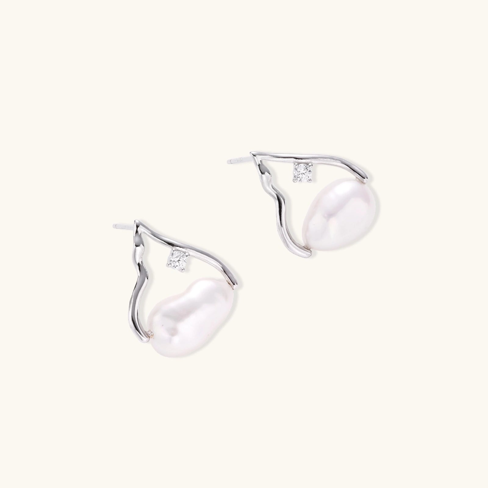 Pair of silver earrings with clear gemstones on a white background