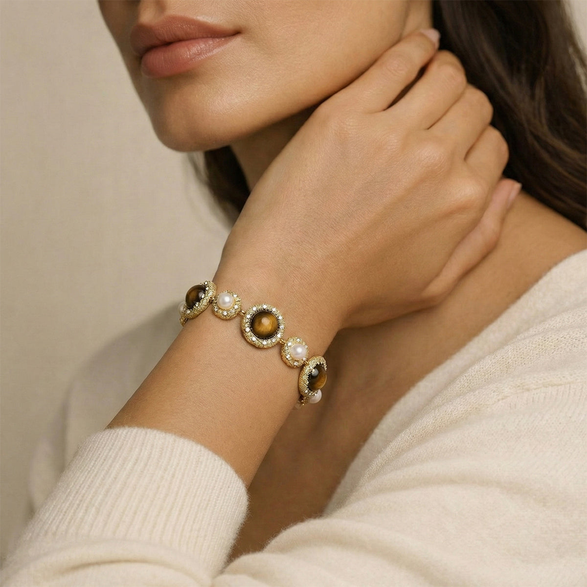 Close-up of a woman's hand wearing a bracelet with circular elements and pearls.